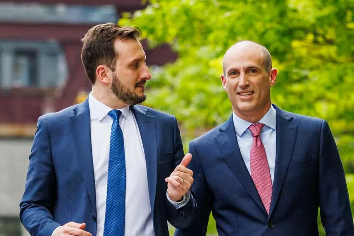 Two Postman Law attorneys walking together along the Chicago Riverwalk.