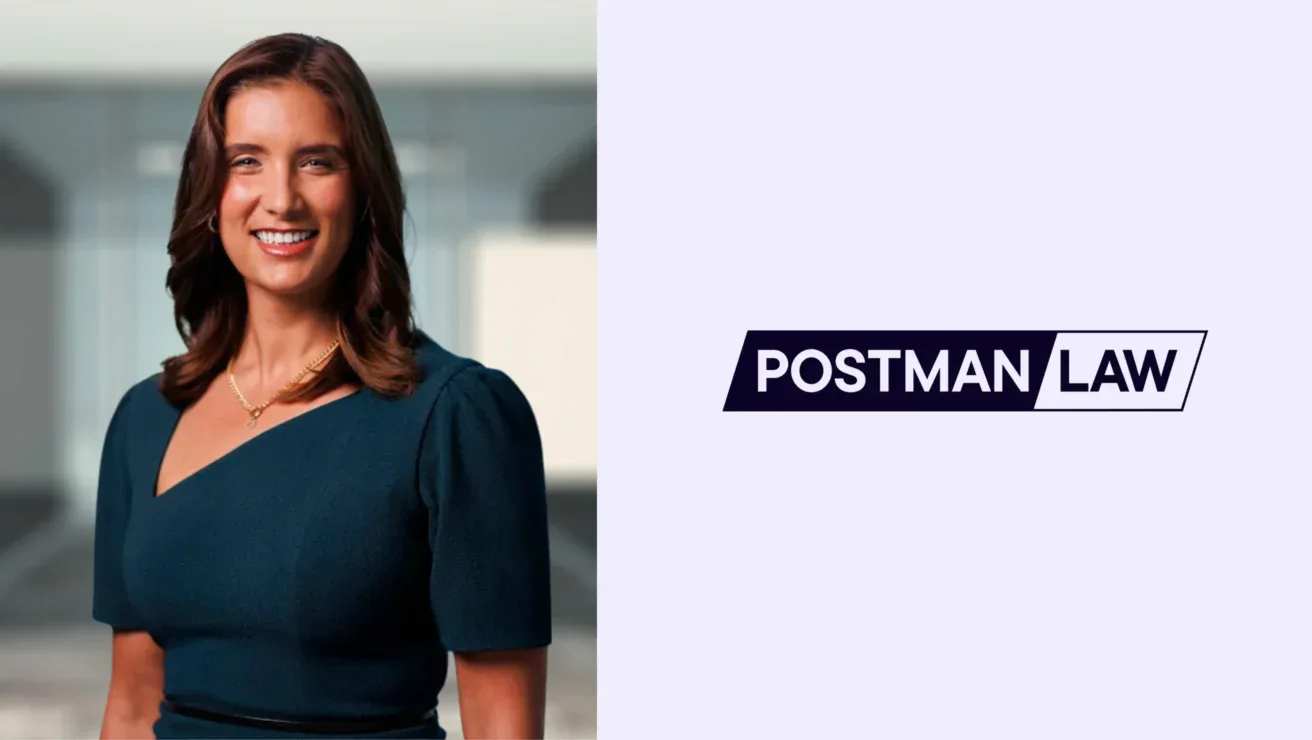 A woman in a dark dress stands smiling in an office setting next to a logo that reads "Postman Law" on a light background.